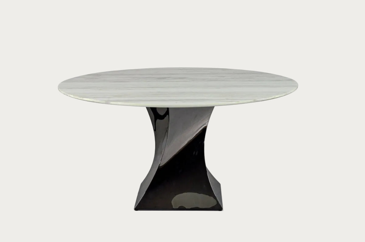 Twist round dining table with a white marble top and black base on a white background