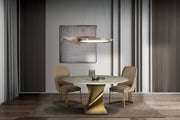 Twist round dining table with chairs, featuring a gold base and marble top.