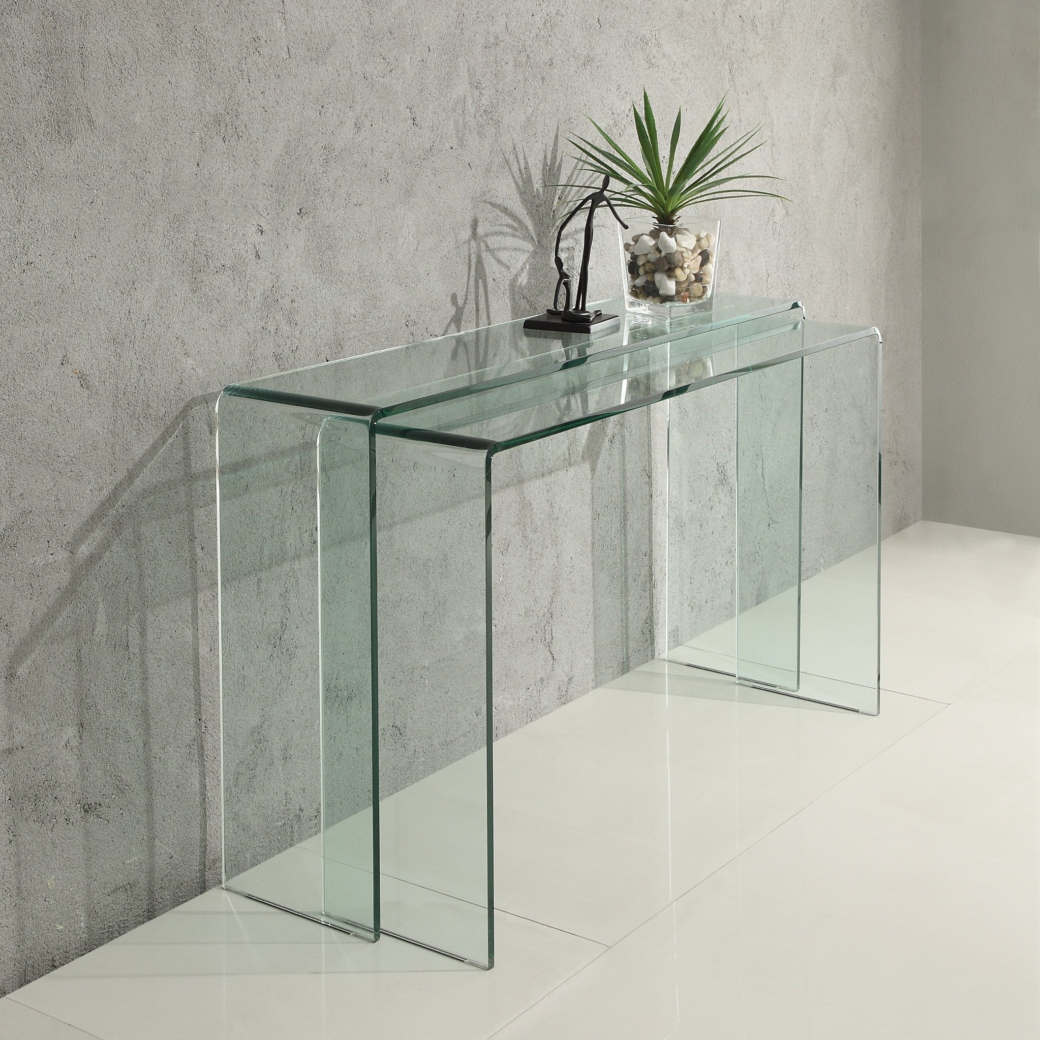 Vision glass console table against a concrete wall.